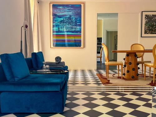 un salon avec un canapé bleu et une table dans l'établissement La Galerie, maison de charme au coeur du Luberon, à Saint-Saturnin-lès-Apt