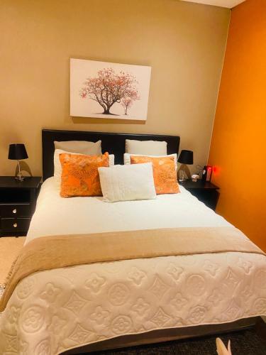 a bedroom with a large bed with orange walls at The Orange Corner in Johannesburg