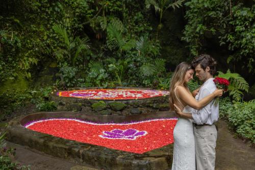 a bride and groom standing in front of a flower carpet at Sacred Valley by GenuineHost in Tegalalang