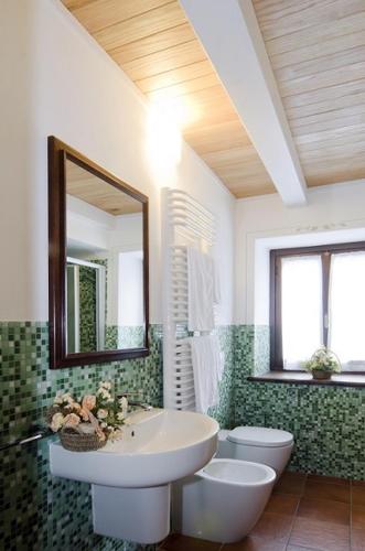 a bathroom with a sink and a toilet and a mirror at Sul Bric Dei Capalot in La Morra