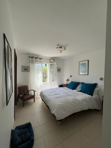 une chambre avec un grand lit et une chaise dans l'établissement Villa 6 Pers Uzes piscine lagon et vue garrigue, à Saint-Maximin