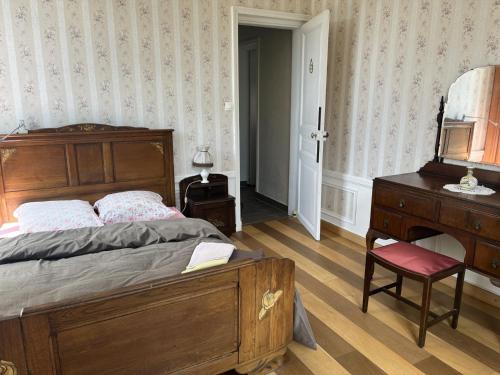une chambre avec un lit, une commode et un miroir dans l'établissement Petit manoir av court de tennis, à Amayé-sur-Orne