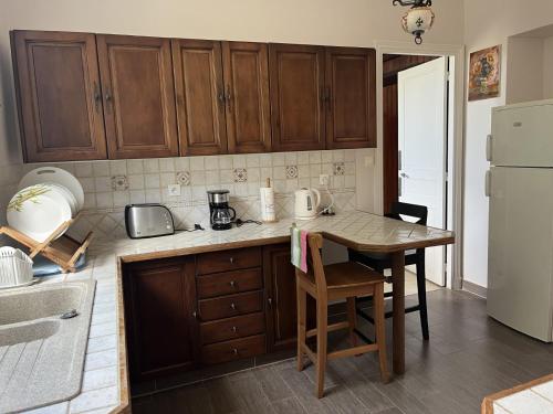 - une cuisine avec des placards en bois, une table et un réfrigérateur dans l'établissement Petit manoir av court de tennis, à Amayé-sur-Orne