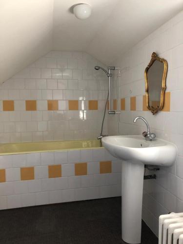 une salle de bain avec un lavabo et une baignoire dans l'établissement Petit manoir av court de tennis, à Amayé-sur-Orne