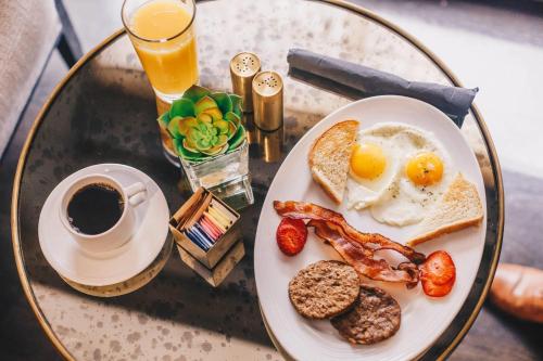 a plate of eggs and bacon on a table with a cup of coffee at Cambria Downtown Phoenix Convention & Airport Hotel in Phoenix