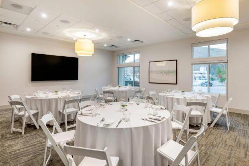 a conference room with tables and chairs and a flat screen tv at Cambria Hotel Calabasas - Malibu in Calabasas