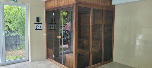a large wooden cabinet in a room with a window at Byblos Wellness Apartman Siófok in Siófok
