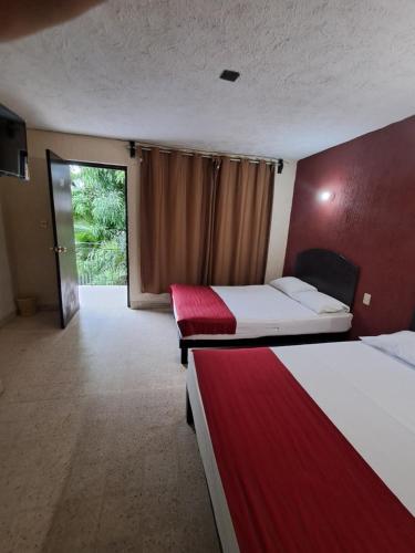 a hotel room with two beds and a balcony at Hotel palacio in Acapulco