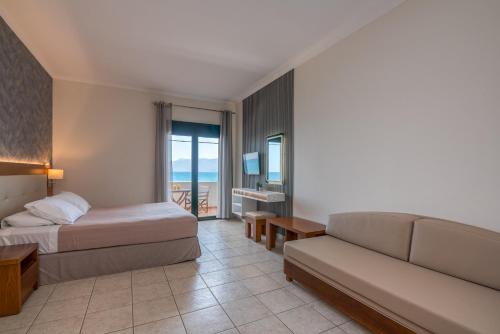 a hotel room with a bed and a couch at Christina Beach Hotel in Kissamos