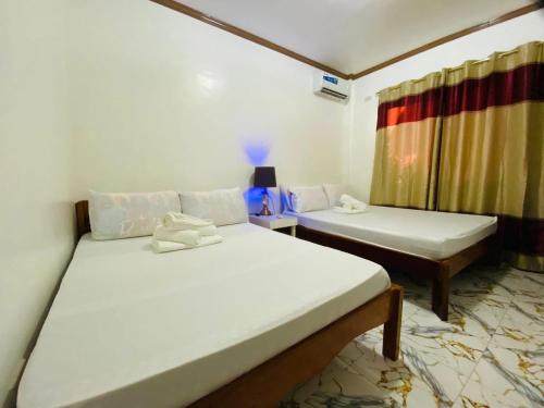 a bedroom with two beds and a window at Foxtail Siargao Island Guesthouse in General Luna