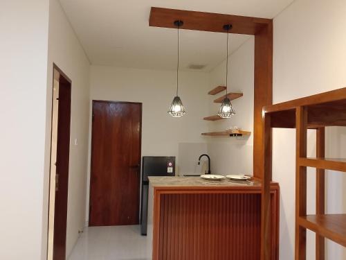 a kitchen with two pendant lights and a counter at Apartemen JIRO BALI in Ngurah Rai International Airport