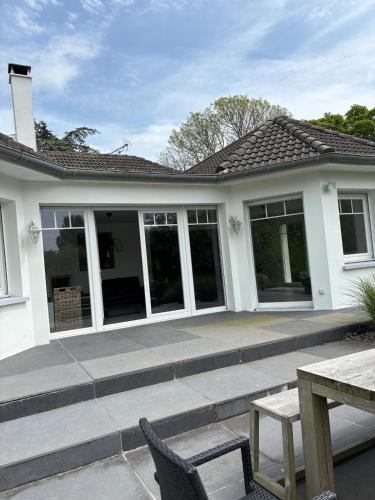 Cette maison blanche dispose d'une terrasse et d'une table. dans l'établissement La vacancière, à Cucq