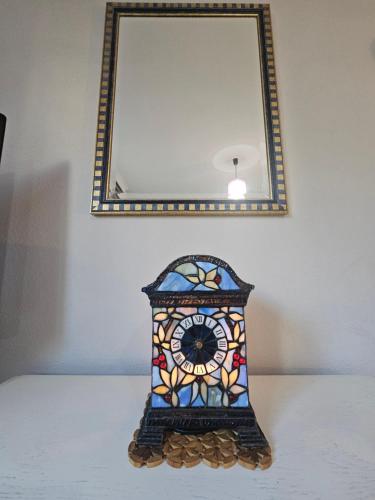 a stained glass clock sitting under a mirror at Apartments Aerodrom in Podgorica
