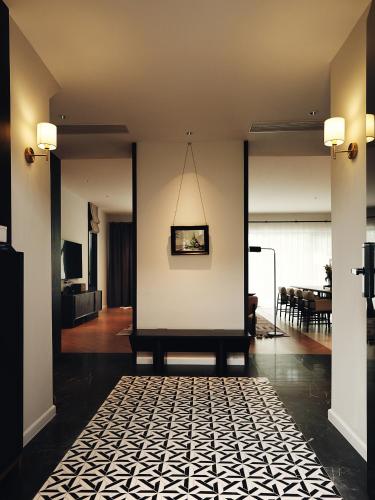 a living room with a white wall and a table at Argo Pattaya Resort and Villas in Ban Huai Yai