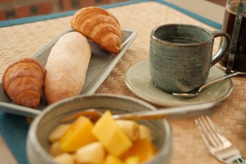a table with a tray of bread and a cup of coffee at PHA NYA RESIDENCE in Luang Prabang