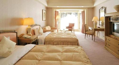 a hotel room with two beds and a television at Hotel de Premiere Minowa in Inawashiro