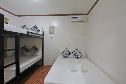 a room with two bunk beds and a table at Foxtail Siargao Island Guesthouse in General Luna