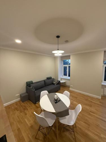 a living room with a couch and a table and chairs at Pine cone cozy apartment in Riga