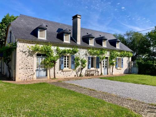 a brick house with windows and a roof at Cottage authentique et chaleureux entre Pau et Lourdes pour 7 personnes in Nousty