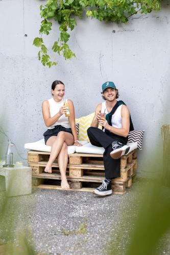 two people sitting on a bench with drinks at DAS SCHÖNE LEBEN Pop-Up Hotel in Hornberg
