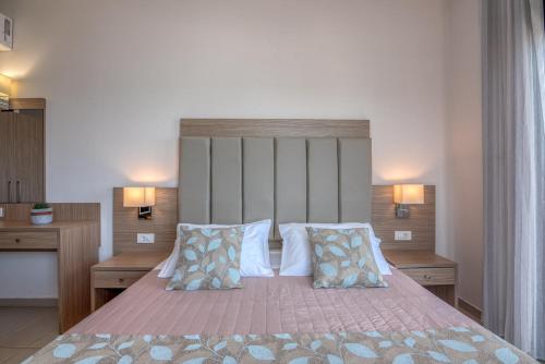 a bedroom with a large bed with two pillows at Christina Beach Hotel in Kissamos