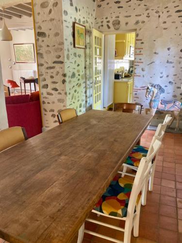 a dining room with a wooden table and chairs at Cottage authentique et chaleureux entre Pau et Lourdes pour 7 personnes in Nousty