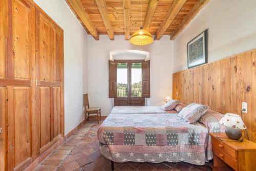 Un dormitorio con una cama y una pared de madera. en El Torrent, en Pinell de Solsonès