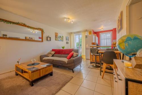 a living room with a couch and a table at Appartement Cosy - Résidence avec Parc et Piscine in Marans