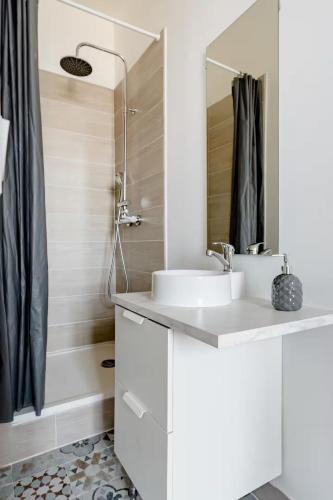 une salle de bain blanche avec un lavabo et une douche dans l'établissement Superbe chambre privée avec douche proche gare TGV, à Marseille