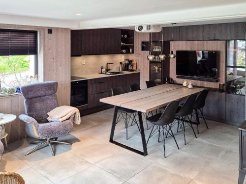 a kitchen with a wooden table and black chairs at 8 person holiday home in averøy-By Traum in Averoy