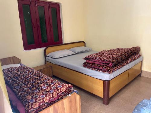 a bedroom with two twin beds and a window at Gujrat Bhawan in Phata