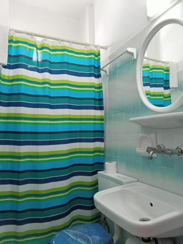 a bathroom with a colorful shower curtain and a sink at Villa Fortin Pension in Kuşadası