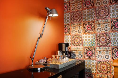 a desk with a lamp on it next to a wall at Yalla Yalla Boutique Hotel in Witbank