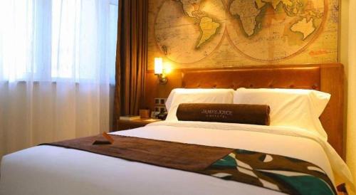 a bedroom with a large bed with a map on the wall at James Joyce Coffetel Shenyang North Railway Station Qishan Road Metro Station in Shenyang