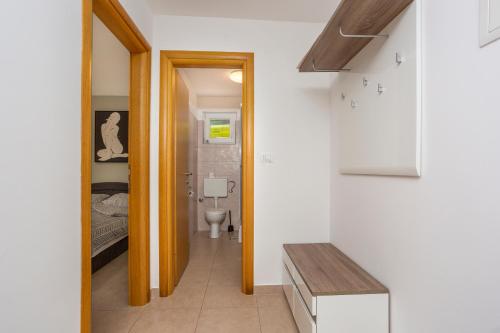 a small bathroom with a toilet and a bedroom at Villa Sbay in Omišalj