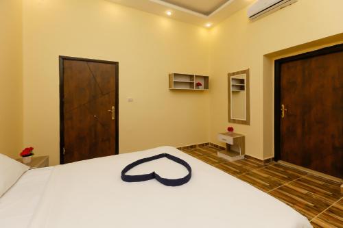 a bedroom with a white bed with a black ribbon on it at Turquoise Pyramids Gate Hotel City Centre in Cairo