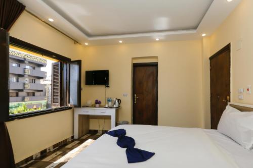 a bedroom with a white bed and a window at Turquoise Pyramids Gate Hotel City Centre in Cairo