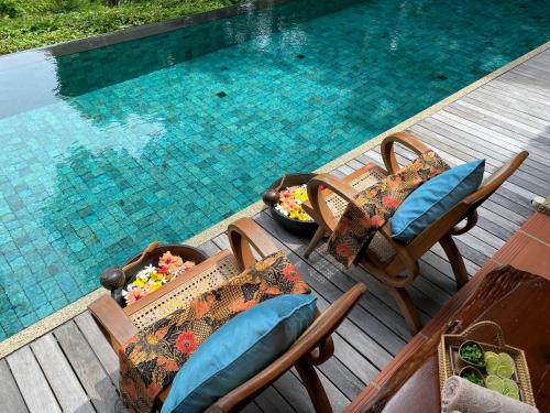 an overhead view of a swimming pool with chairs and a table at Ambong Pool Villas - Private Pool in Pantai Cenang