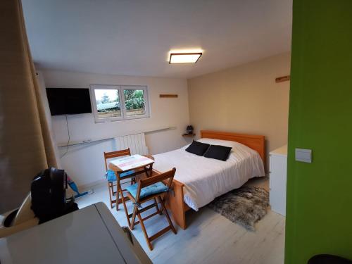 une chambre avec un lit, une table et des chaises dans l'établissement La petite cabane, à Honfleur