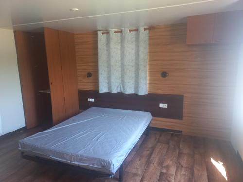 une chambre avec un lit dans une pièce avec une fenêtre dans l'établissement Cottage adapté PMR, à Ligné