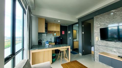 a kitchen with a counter and a tv in a room at Palam Mansion at Apartment One Residence in Batam Center
