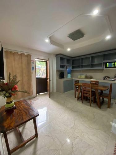 a living room with a table and a kitchen at Foxtail Siargao Island Guesthouse in General Luna