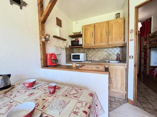 une petite cuisine avec une table et un micro-ondes dans l'établissement Résidence Les Alpages - Studio skis aux pieds en rez-de-jardin MAE-3833, à Notre-Dame-de-Bellecombe