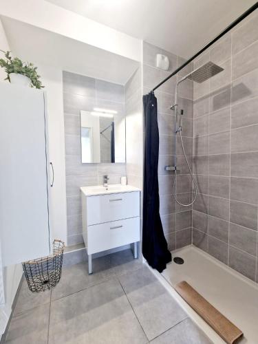 une salle de bain avec un lavabo blanc et une douche dans l'établissement Toit-terrasse avec vue magnifique sur Montpellier, à Montpellier