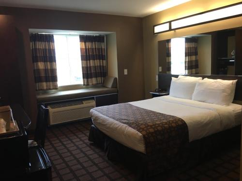 a hotel room with a large bed and a window at Microtel by Wyndham Perry National Fairground Area I-75 in Perry