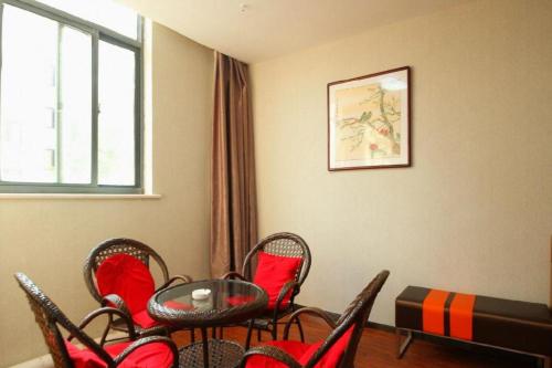 une pièce avec une table, des chaises et une fenêtre dans l'établissement 7 Days Premium·Guanyun Nanjing West Road Hesheng Plaza, à Guanyun