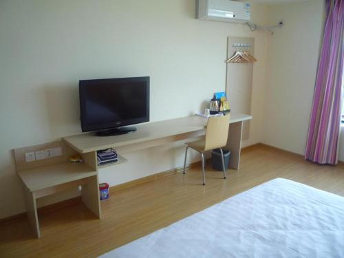 a room with a desk with a television and a chair at 7 Days Inn Suzhou Wangting Pearl Commercial Plaza in Suzhou