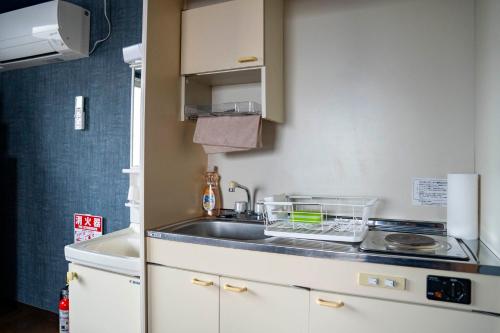 a small kitchen with a sink and a stove at Silk Court 301 in Chitose