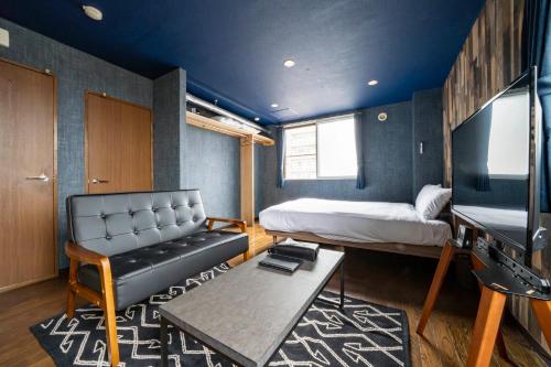 a room with a bed and a couch and a tv at Silk Court 301 in Chitose