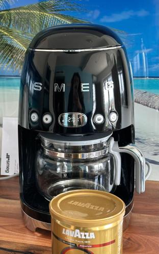 a black coffee maker sitting on a table with a cup at Morze, Basen&SPA i Spokój Apartament 2 Pięć Mórz w Sianożętach in Sianozety